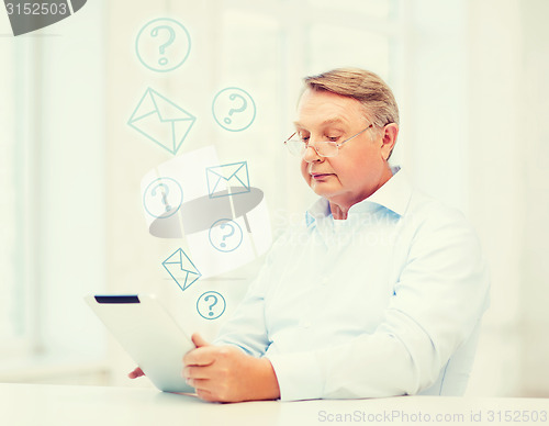 Image of old man with tablet computer at home