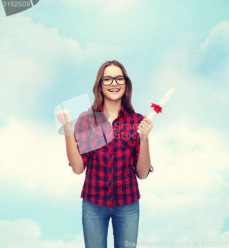 Image of smiling female student in eyeglasses with diploma