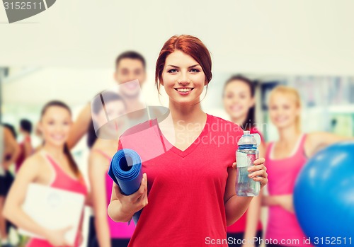 Image of smiling girl with bottle of water after exercising