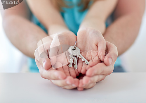 Image of close up of man and girl hands with house keys