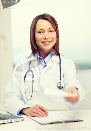 Image of smiling doctor with laptop computer and clipboard
