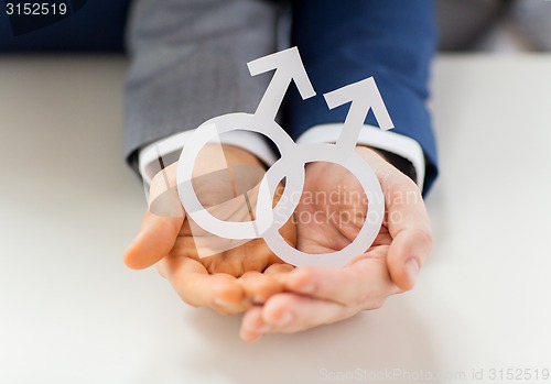 Image of close up of happy male gay couple with love symbol