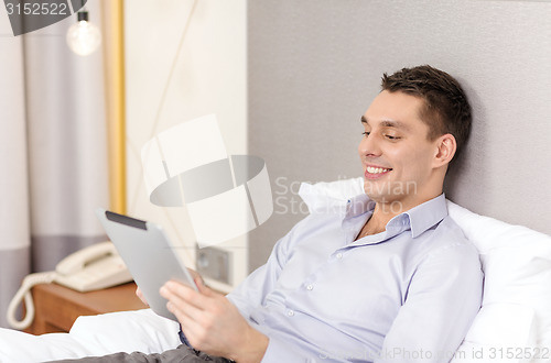 Image of happy businesswoman with tablet pc in hotel room