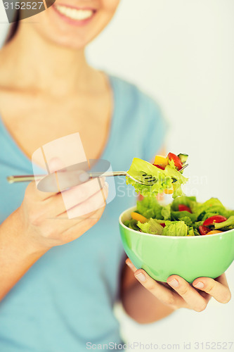 Image of woman eating salad with vegetables