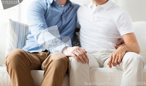 Image of close up of happy male gay couple hugging at home