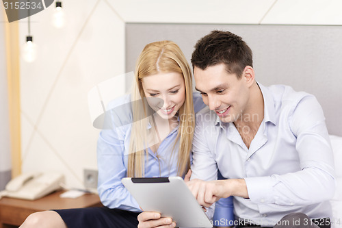 Image of couple with tablet pc computer in hotel room