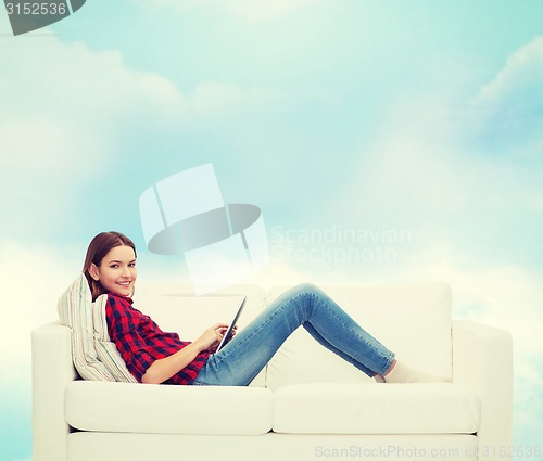 Image of teenage girl sitting on sofa with tablet pc