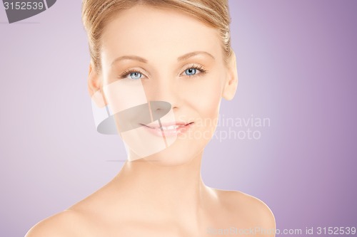 Image of beautiful young woman face over violet background