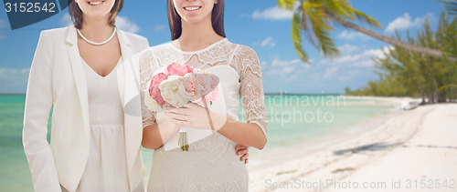 Image of close up of happy lesbian couple with flowers