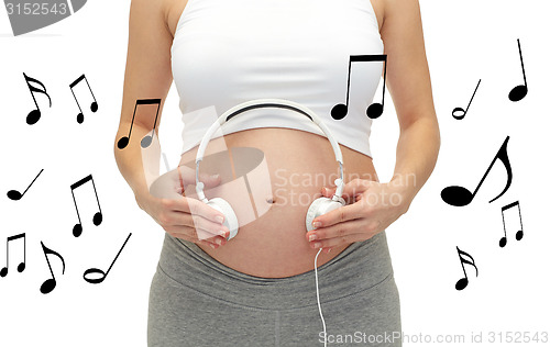 Image of close up of pregnant woman and headphones on tummy