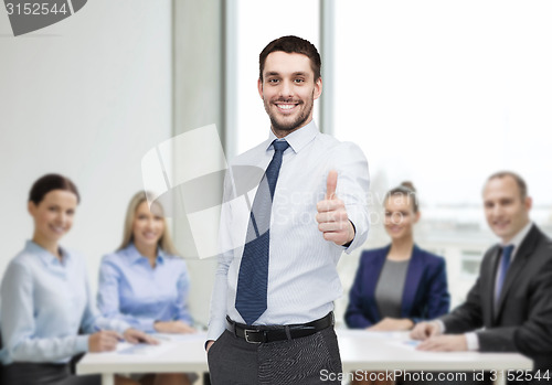 Image of handsome businessman showing thumbs up