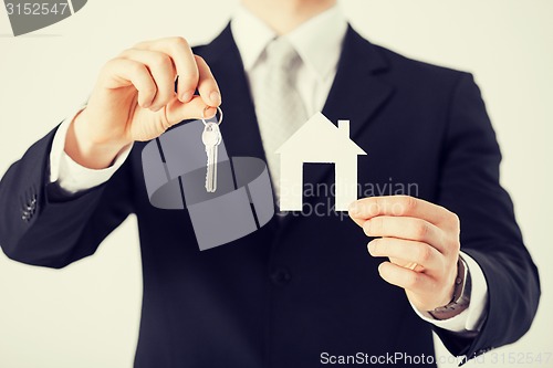Image of man holding house keys and paper house