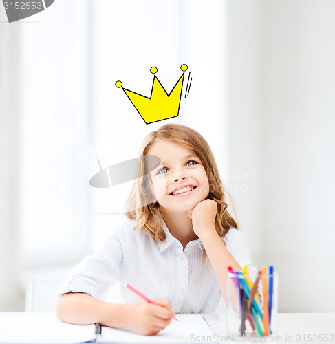 Image of smiling little school girl drawing at home