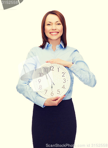 Image of attractive businesswoman with wall clock