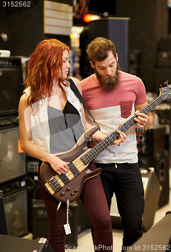 Image of musicians playing bass guitar at music store