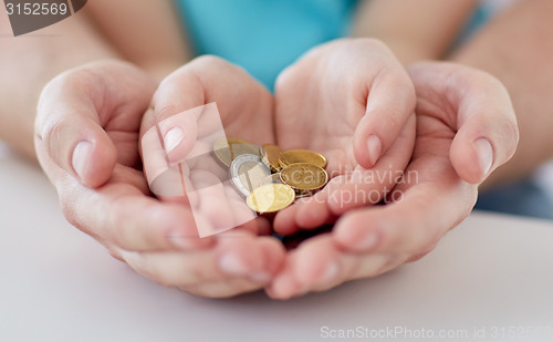 Image of close up of family hands holding euro money coins