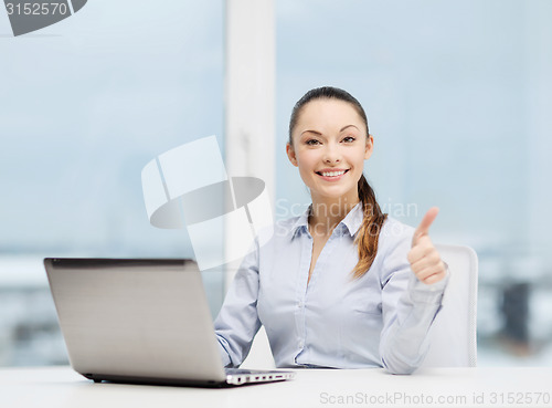 Image of businesswoman with laptop in office