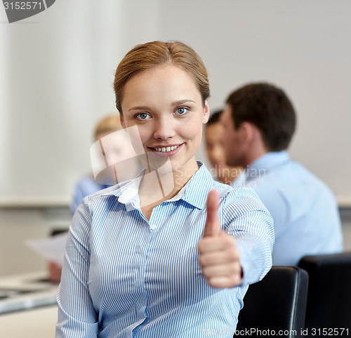 Image of group of smiling businesspeople meeting in office