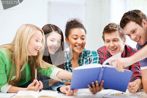 Image of students reading book at school