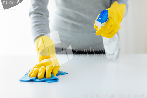 Image of close up of woman cleaning table with cloth