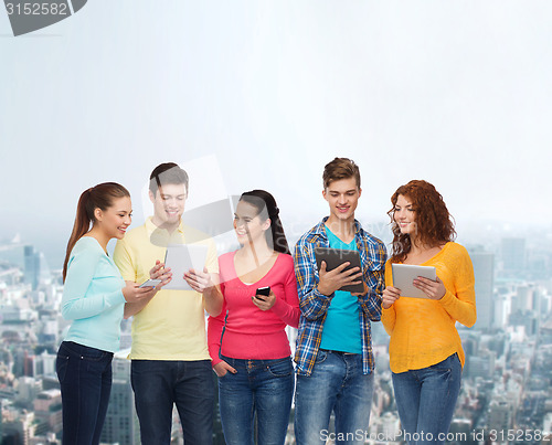 Image of group of teenagers with smartphones and tablet pc