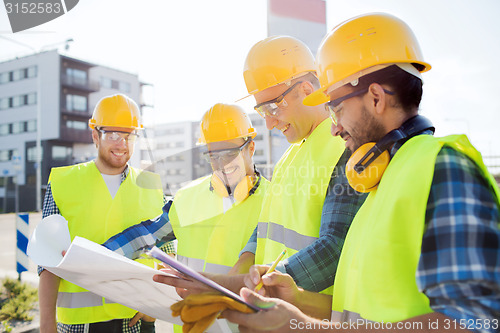 Image of group of builders with tablet pc and blueprint