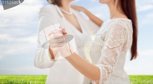 Image of close up of happy married lesbian couple dancing