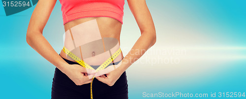 Image of close up of female hands measuring waist