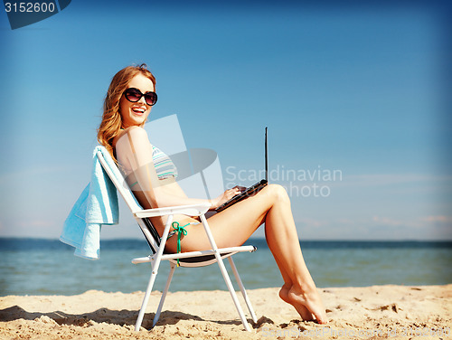 Image of girl looking at tablet pc on the beach