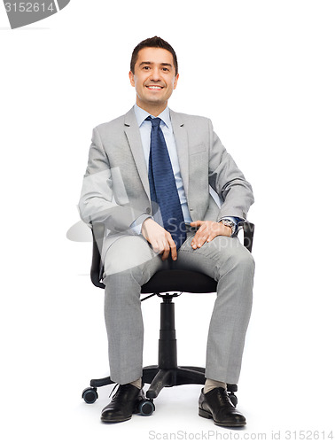Image of happy businessman  sitting in office chair