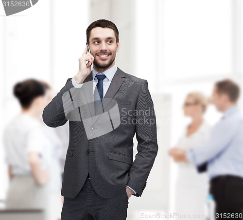 Image of young smiling businessman with smartphone