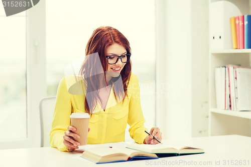 Image of smiling student girl reading books in library