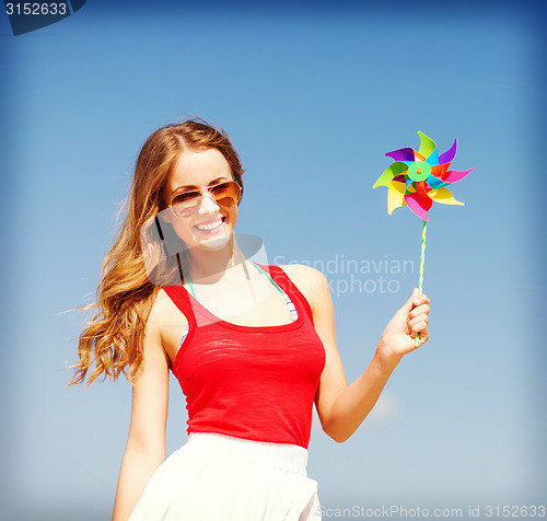 Image of girl with windmill toy on the beach