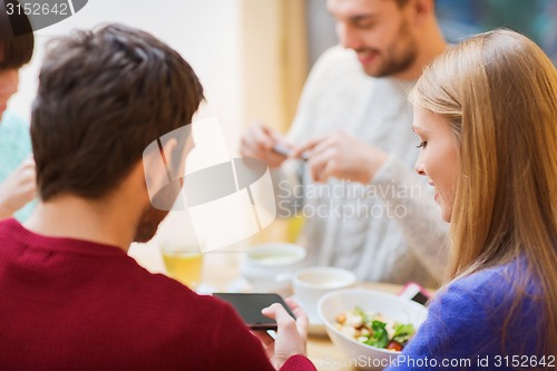 Image of group of friends with smartphones meeting at cafe