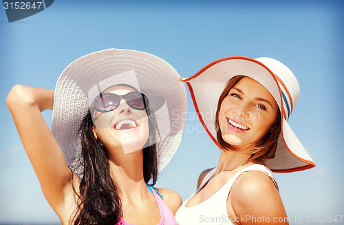 Image of girls in hats on the beach