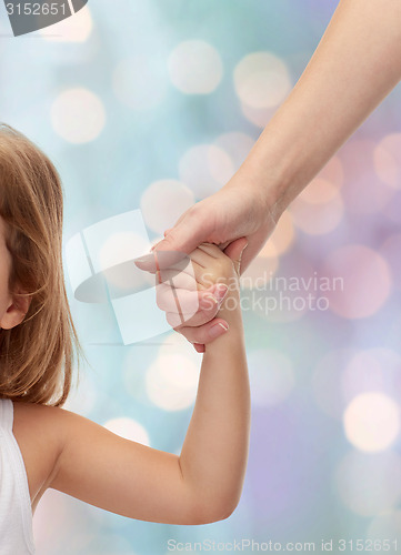 Image of close up of woman and little girl holding hands