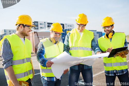 Image of group of builders with tablet pc and blueprint