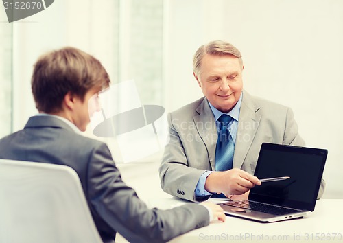 Image of older man and young man with laptop computer