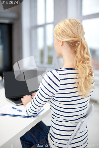 Image of close up of student with laptop and notebook