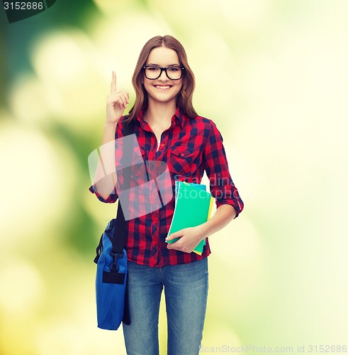 Image of smiling female student with bag and notebooks