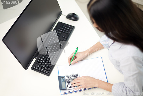 Image of close up of woman with calculator counting