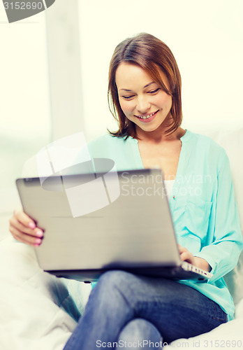 Image of smiling woman with laptop computer at home