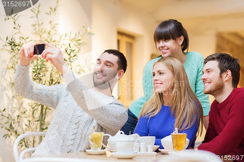 Image of group of friends taking selfie with smartphone