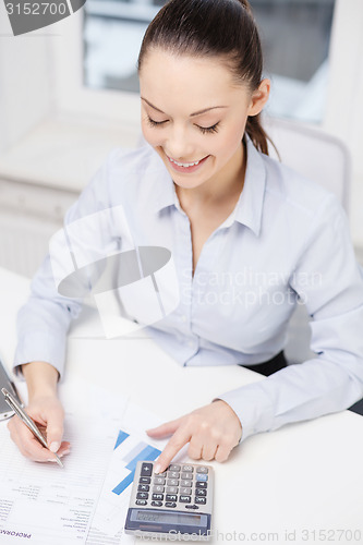 Image of businesswoman working with documents in office