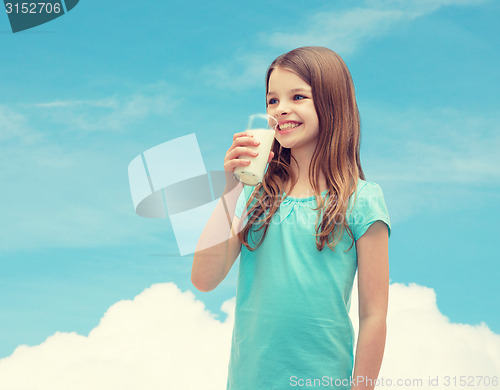 Image of smiling little girl drinking milk out of glass