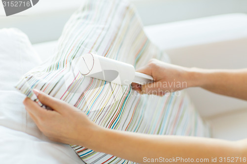 Image of close up of woman hand with sticky roller cleaning