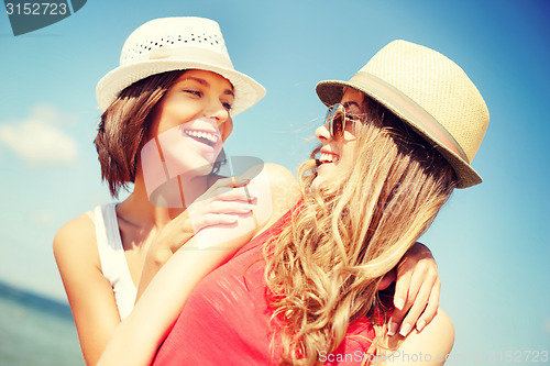 Image of girls in hats on the beach