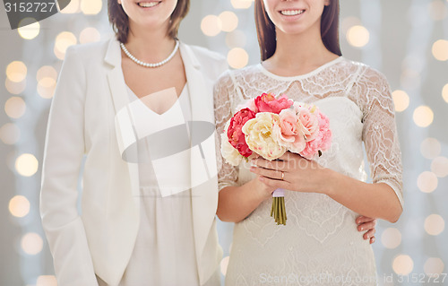 Image of close up of happy lesbian couple with flowers