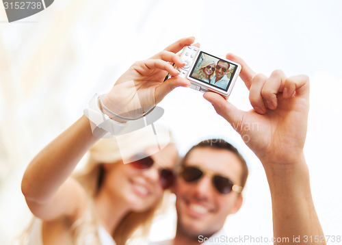 Image of travelling couple taking photo picture with camera