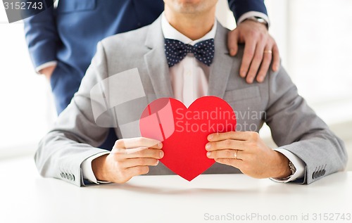 Image of close up of male gay couple with red heart